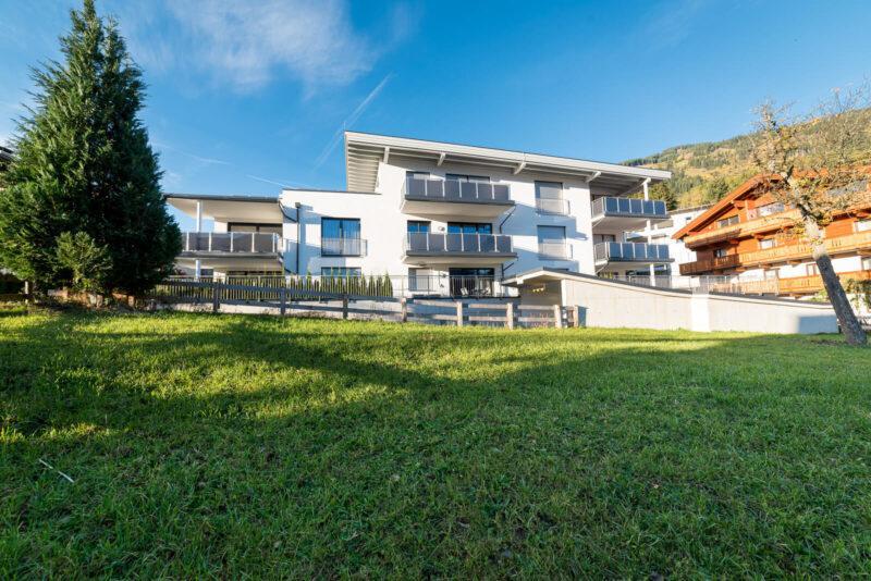 Man sieht das Haus über eine kleine Weide für die Kälber